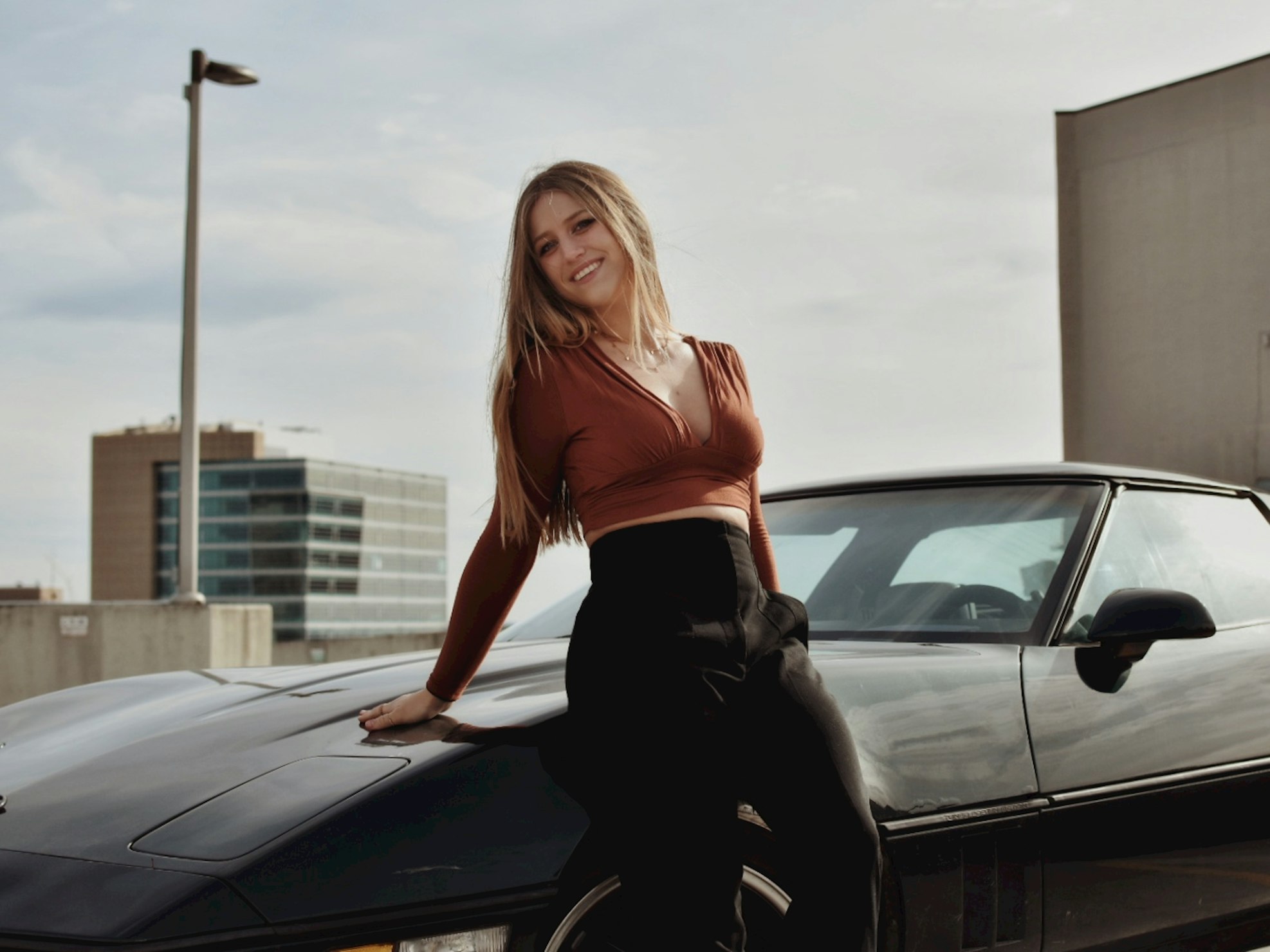 Woman sitting on car with repaired windshield.